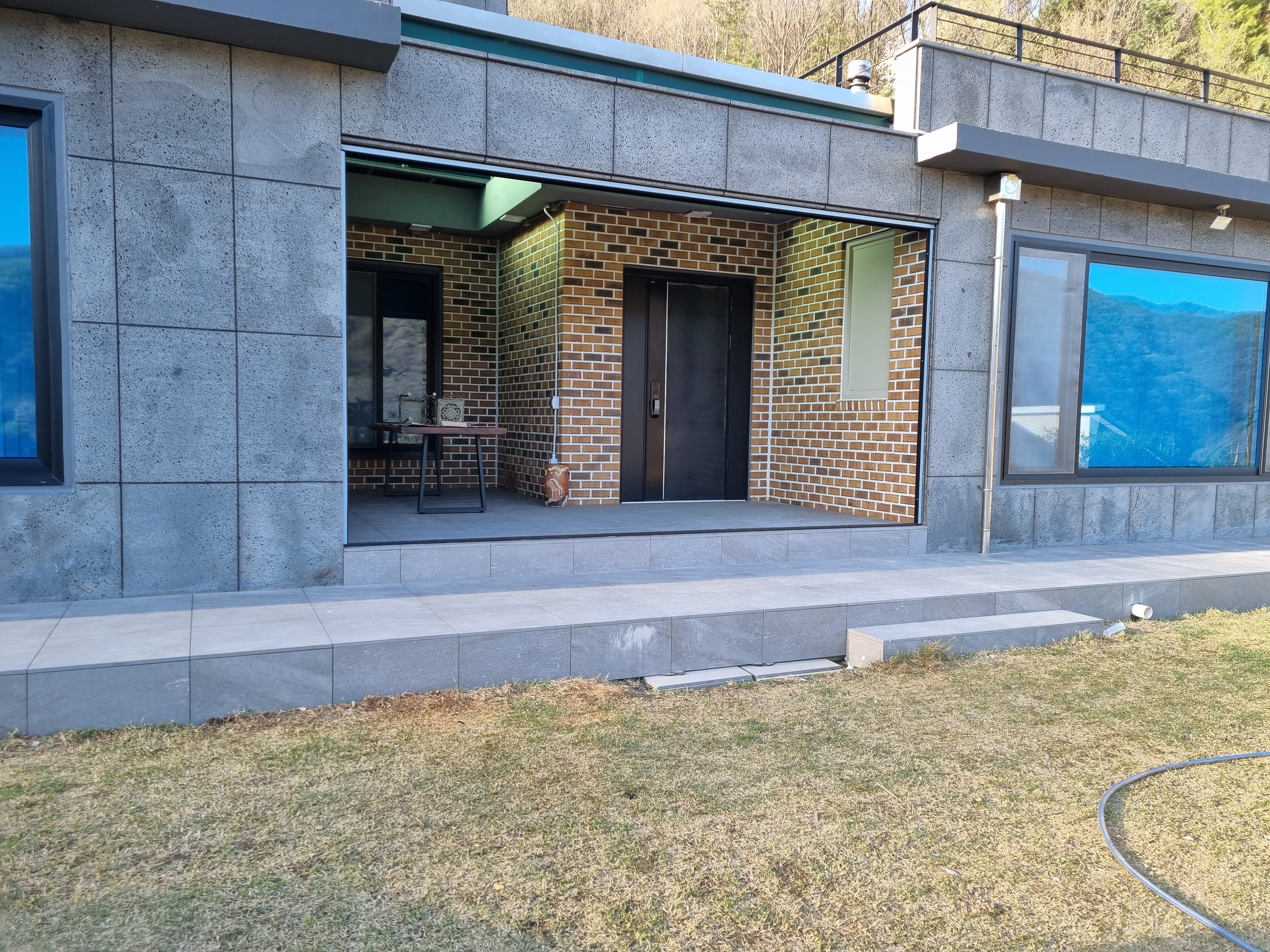 제천 전원주택 데크 — 완공된 그레이 포세린 타일 데크 — 현관 진입부